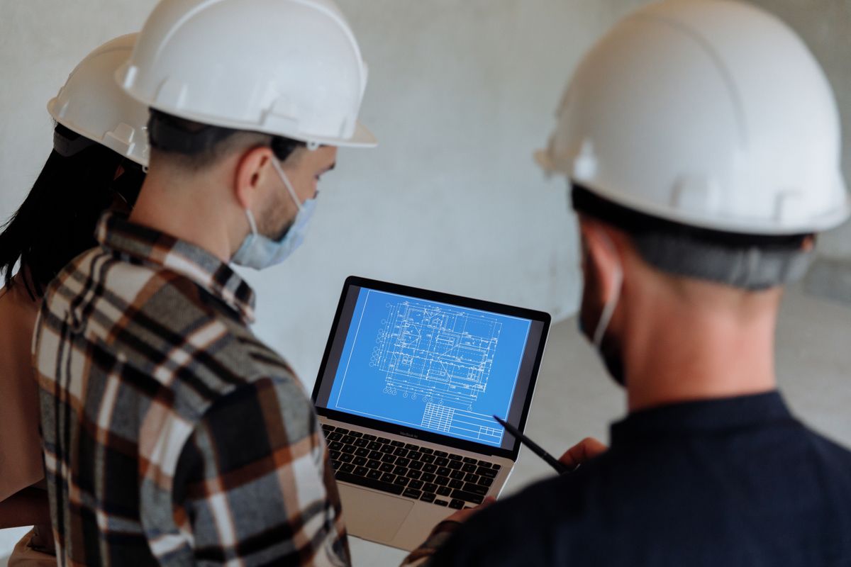 Professionals reviewing building plans on a laptop